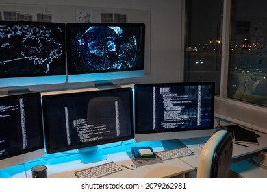 Part Of Large Openspace Office Of Programming Company With Long Desk And Several Computer Monitors With Coded Data