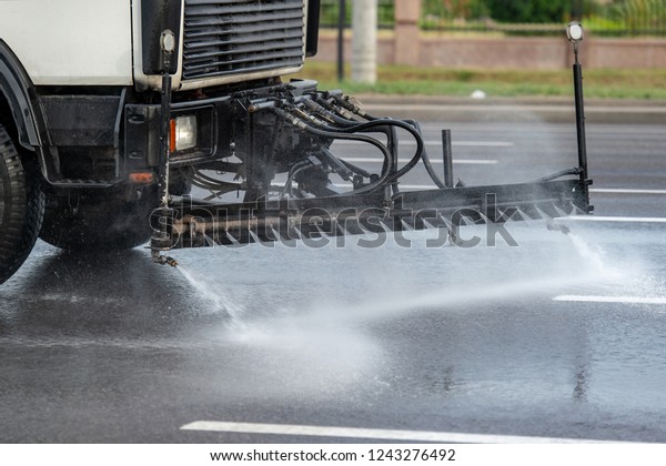 Part of machine for cleaning city\
sidewalks from dust and dirt. Equipment moving on road and clean\
asphalt with water. Cleaning city car front\
view