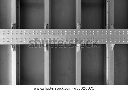 Part of a massive metal structure with rivets. Black and white image