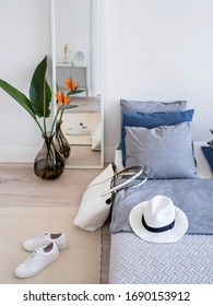 Part Of A Modern Minimalist Feminine Bedroom In A Perspective View With Rug, Bed, An Exotic Flower And White Framed Mirror. Scandinavian Style Interior And White Summer Accessories For Hipster Girls.