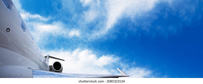 Part Of Modern Private Jet Airplane With A Tail And Wing Over Sky Background, Panoramic Layout With Space For Text