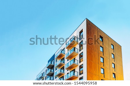 Part of Modern residential apartment with flat building exterior. Detail of New luxury house and home complex. Fragment of City Real estate property and condo architecture. Copy space. Blue sky