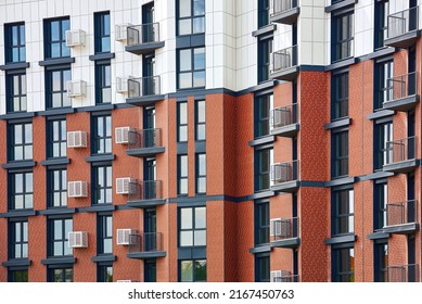 Part of new modern residential apartment building exterior. Detail of new house and home complex. Urban real estate property. Facade with decorative air conditioner covers, glass windows and balconies