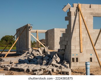 Part of new wall of concrete blocks and reinforcing bars blown down by Hurricane Ian (September 2022)  on construction site of single-family house in a suburban development in southwest Florida - Shutterstock ID 2224381875