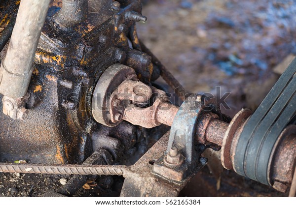 Part of the old rusty gearbox\
and drive shaft with grunge oil dirty, Vintage engine car\
system.