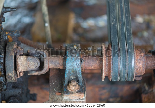 Part of the old rusty gearbox\
and drive shaft with grunge oil dirty, Vintage engine car\
system.