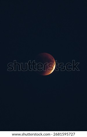 The part is only covered by shadow. The lunar eclipse or blood moon photo in the night sky.