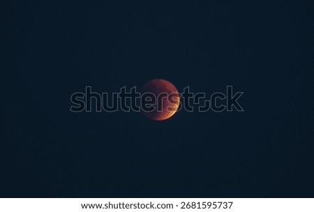 The part is only covered by shadow. The lunar eclipse or blood moon photo in the night sky.