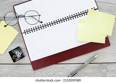 A Part Of Open Daily Planner On Wooden Background With Purple Fountain Pen. Copyspace Template And Branding Mockup. Ready To Write Text.