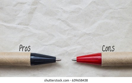 Part of pens on brown paper with word 'Pros and Cons', decision and comparision concept 
