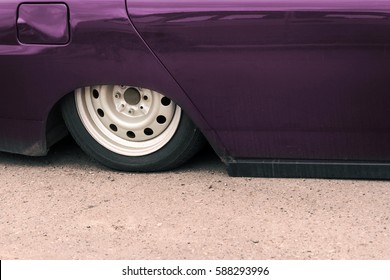 Part Of A Purple Car With Pneumatic Suspension On The Pavement