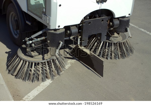 Part of road cleaning machine with round front\
brushes closeup