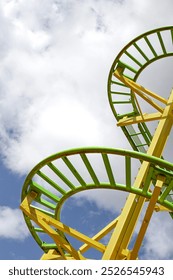 Part of a roller coaster and cloudy blue sky on background