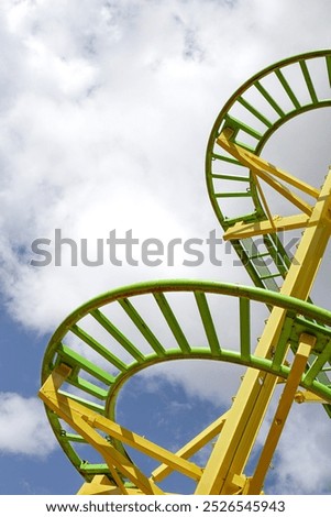 Part of a roller coaster and cloudy blue sky on background