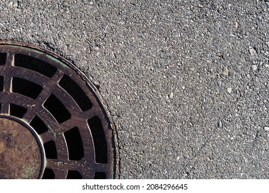 Part Of A Round Manhole With Grating On The Asphalt. View From Above