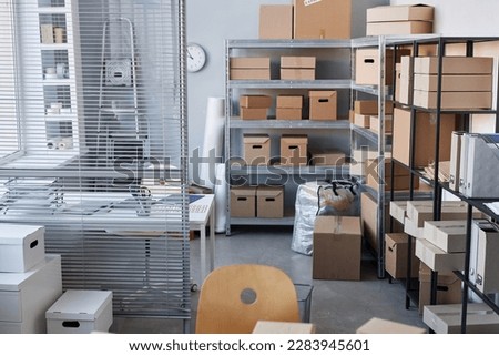 Part of spacious warehouse with stacks of packed cardboard boxes containing goods ordered by clients of online shops
