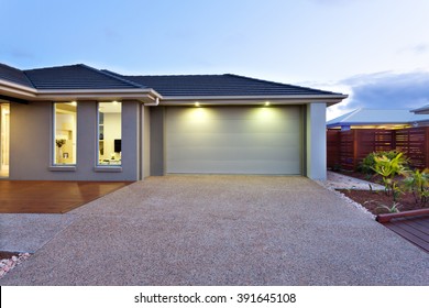 Part Of This Luxury House Includes A Garage With A White Door And Illuminated By Two Small Lights Under The Ceiling.