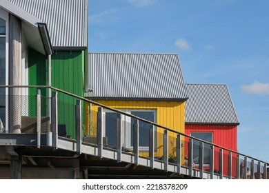 Part Of Three Scandinavian Style Colored Wooden Houses In A Row. Green, Yellow And Red Buildings.