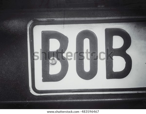 Part of a vehicle registration plate with the name\
Bob, in black and white