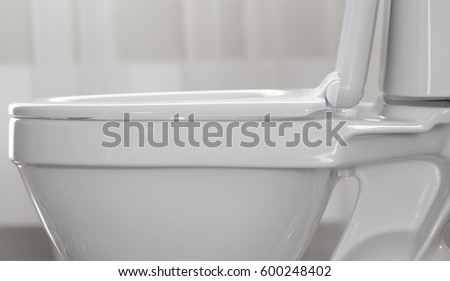 Part of white toilet bowl close-up.
