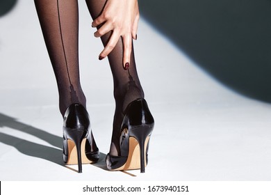 Part of woman body perfect shape legs feet skin tan wear stockings, nylons, pantyhose lingerie hosiery hose studio shot. on white background high heels.