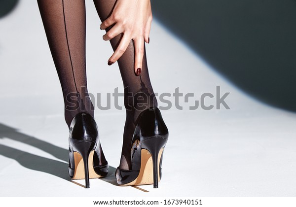 Part of woman body perfect shape\
legs feet skin tan wear stockings, nylons, pantyhose lingerie\
hosiery hose studio shot on white background high\
heels.