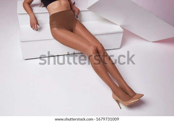 Part of woman body perfect shape legs feet\
skin tan wear stockings, nylons, pantyhose lingerie hosiery hose\
studio shot. on white\
background.