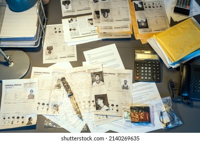 Part of workplace of contemporary fbi agent with criminal profiles, calculators, telephone, packets with clues and other stuff