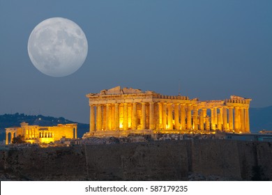 Parthenon temple in Acropolis Hill in Athens, Greece shot in blue hour with the moon rising above the sky
