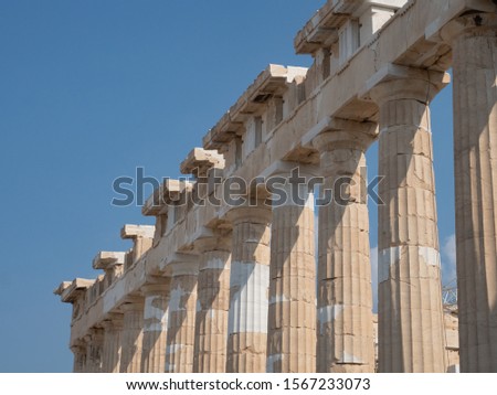 Parthenon's row of ridged Doric columns with simple capitals on top, all made of marble. Photographed in the Acropolis in Athens, Greece.