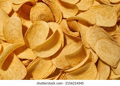 Partial Close Up Background Texture Of Heap Of Delicious And Appetizing Potato Chips. Unhealthy Eating And Junk Food. Crispy And Spicy High-calorie Snack For Leisure. Nobody