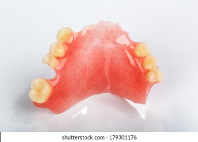 A partial denture on a shiny gray background