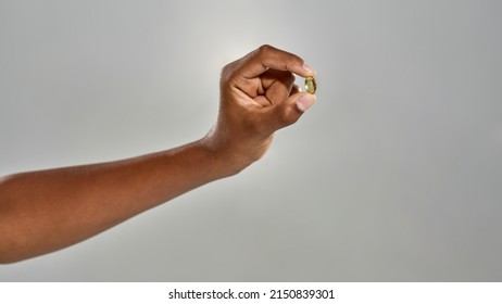 Partial Image Of Black Boy Hand Holding Medical Pill. Concept Of Modern Child Healthy Lifestyle. Idea Of Health Care Protection. Isolated On Grey Background. Studio Shoot. Copy Space