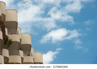 Partial low angle view of apartment building over blue sky with clouds