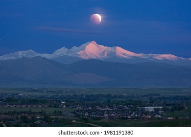 Partial Lunar Eclipse Setting Over A Long's Peak, Illuminated By The Sunrise. 