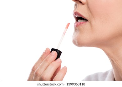 Partial Shot Of Mature Woman Applying Lip Gloss Isolated On White 