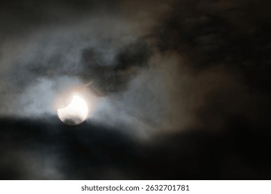 Partial solar eclipse behind turbulent clouds