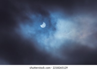 Partial solar eclipse on October 25 2022. Moon, sun and clouds. Part of a series