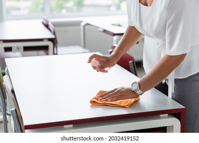 partial view of african american teacher disinfecting desk with antiseptic - Powered by Shutterstock