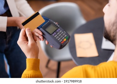 Partial View Of Arabian Man Hold Credit Card Near Payment Terminal In Hands Of Waitress