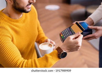 partial view of arabian man paying through payment terminal in hands of waitress - Powered by Shutterstock