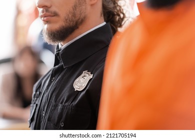 partial view of bearded bailiff in black uniform in court