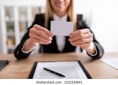 Partial View Of Blurred Notary Holding Blank Business Card