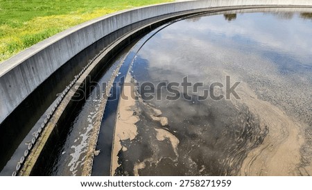 Partial view of a circular primary clarifier in where suspended solids settle to form primary sludge, while oils and scum are removed from the surface