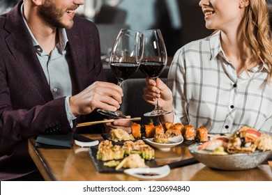 Partial view of couple clinking and having date in restaurant