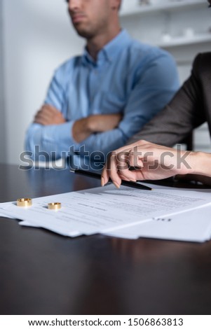 partial view of couple at table with divorce documents