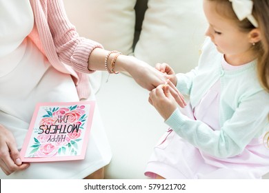 Partial View Of Cute Little Girl Putting Jewelry On Hand Of Her Mother On Mothers Day