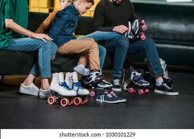 Partial View Of Family Wearing Roller Skates Before Skating In Skate Park