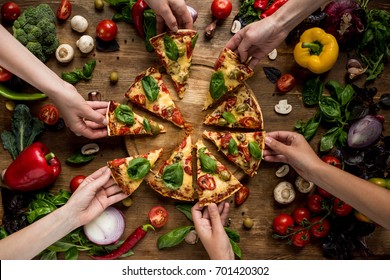 Partial View Of Friends Taking Homemade Pizza Slices 