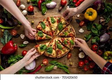 Partial View Of Friends Taking Homemade Pizza Slices 